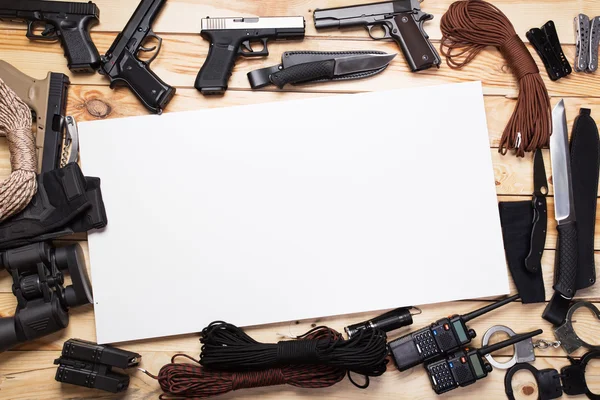 gun,military knife and compass on the wooden table