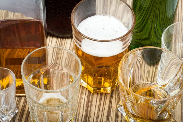 Beer in the glass and covers on wooden table — Stock Photo, Image