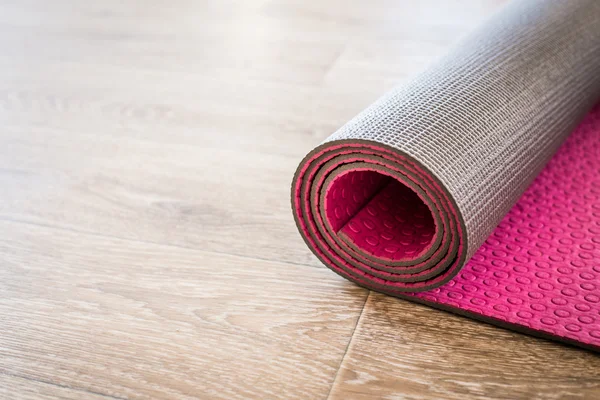 Yoga mat on wooden floor — Stock Photo, Image