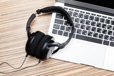 Masa üstünde laptop ile kulaklıklar