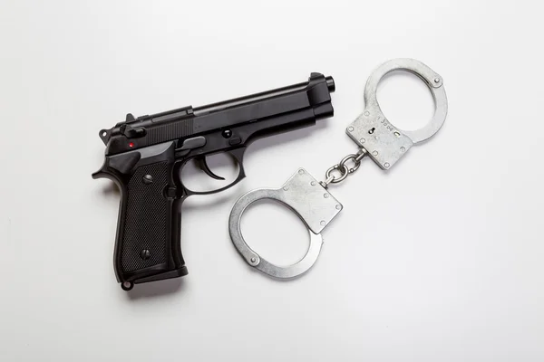 Pistola a mano nera con manette — Foto Stock