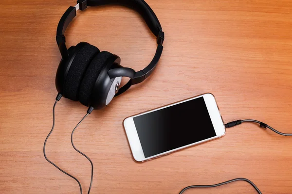 Kopfhörer und iPod auf dem Schreibtisch — Stockfoto