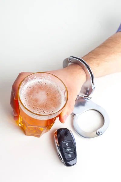 Mão algemada com copo de cerveja — Fotografia de Stock