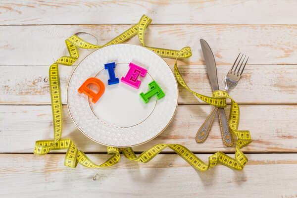 измерительная лента и столовые приборы
