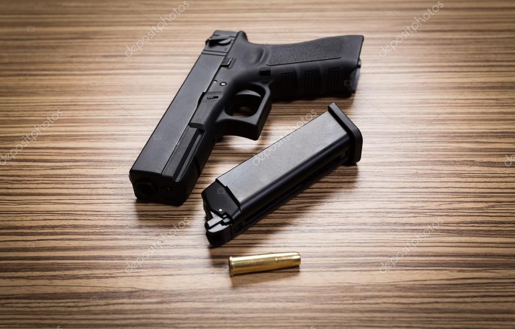 Hand gun with magazine on desks Stock Photo by ©Fotofabrika 110654630