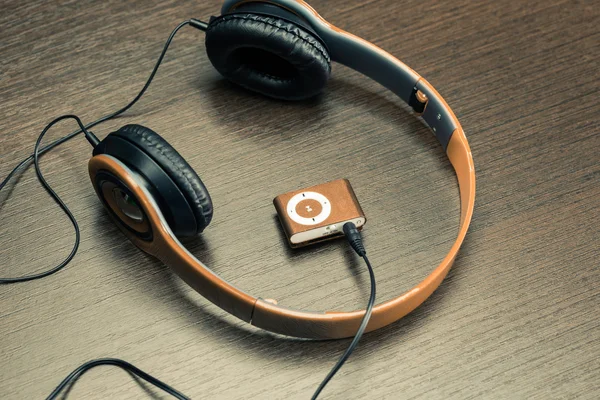 Headphones and ipod on desk — Stock Photo, Image