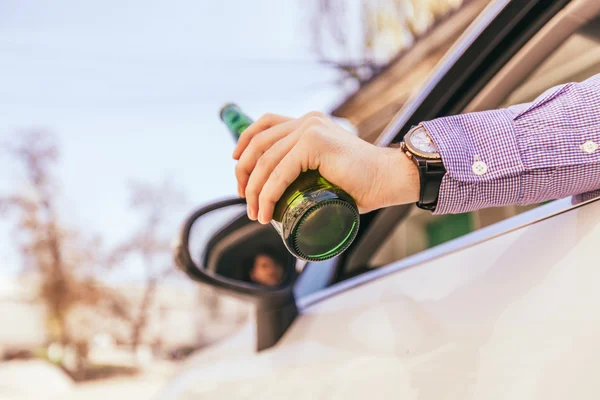Мужчина пьет алкоголь за рулем — стоковое фото