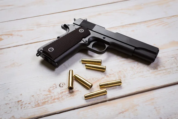 Pistola de mão com balas em mesas — Fotografia de Stock