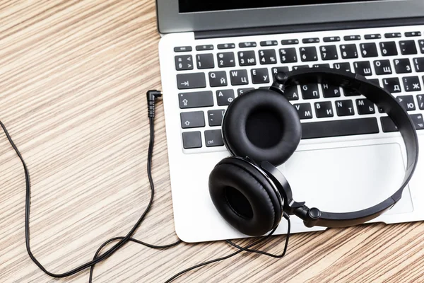 Masa üstünde laptop ile kulaklıklar