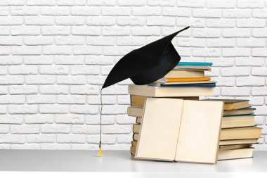books and black mortarboard clipart