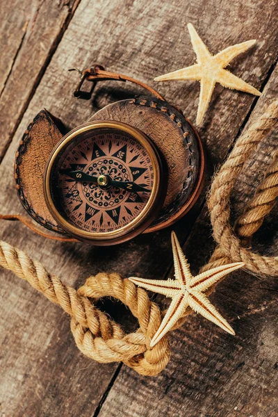 Schip touwen en kompas op houten achtergrond — Stockfoto