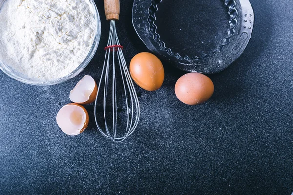 Backen dunklen Hintergrund mit leerem Kochbuch, Eierschale, Brot, Mehl, Nudelholz. Zutaten für das Backen. — Stockfoto