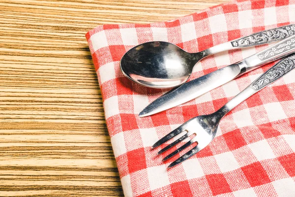 Garfo e faca de mesa na toalha de mesa de gingham vermelho — Fotografia de Stock