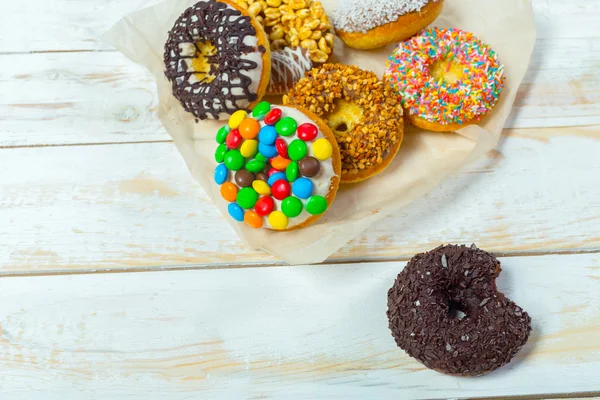 Sammlung schmackhafter Donuts auf weißem Holzbrett — Stockfoto