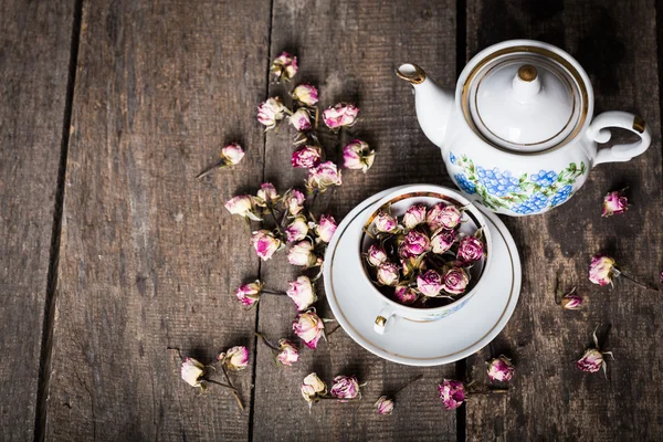 Vintage Teekanne und Tasse mit blühenden Teeblumen auf Holzgrund — Stockfoto