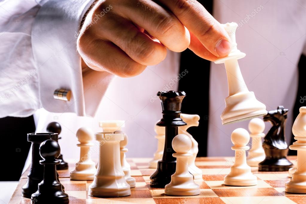 Hand of businessman playing chess