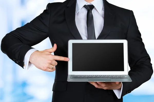 Affärsman holding och visar laptop — Stockfoto