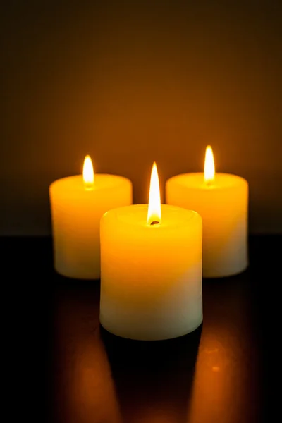 Drie brandende kaarsen in duisternis — Stockfoto