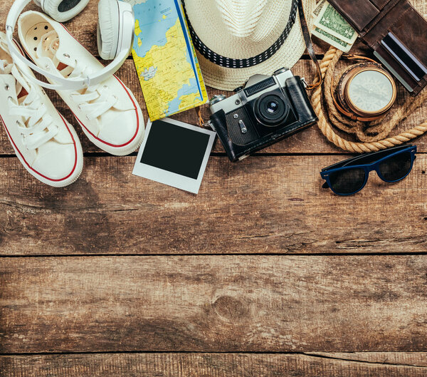 Small set of trip stuff on wooden background, clothes, documents and electronics