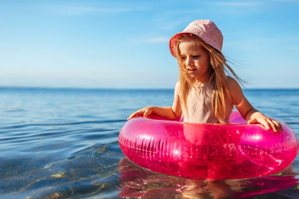 Jeune fille en panama rose nageant dans la mer avec cercle — Photo