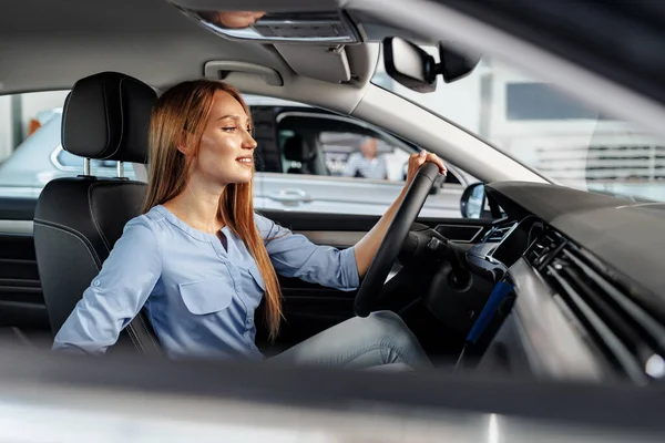 Щаслива жінка новий власник автомобіля сидить на сидінні водія — стокове фото