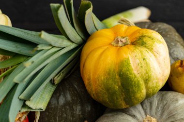 Koyu arkaplanda yığılmış yeşil balkabakları ve yeşiller