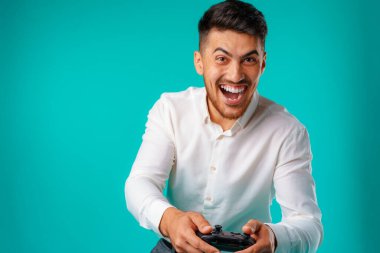 Oyun kumandası tutan yakışıklı, melez bir adam.