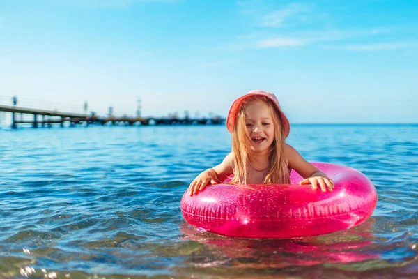 Bonne petite fille se baignant dans la mer avec cercle rose — Photo