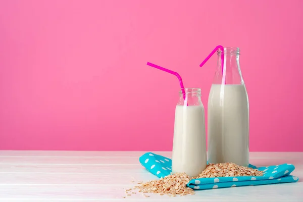 Dos botellas de vidrio de leche o batido sobre fondo rosa — Foto de Stock