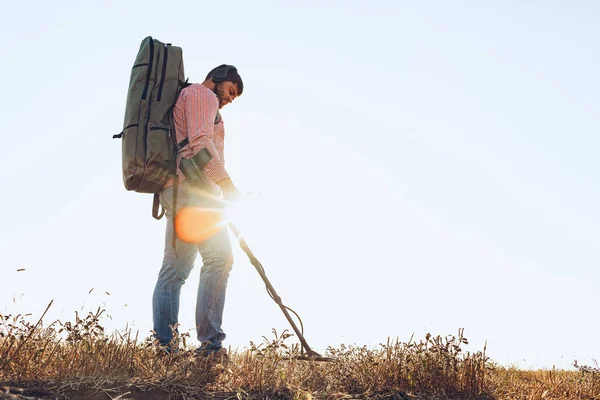 Man with metal detector equipment searching for metal goods in the field — Stock Photo, Image