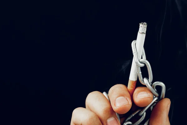 Mano masculina en cadenas metálicas sosteniendo cigarrillo —  Fotos de Stock