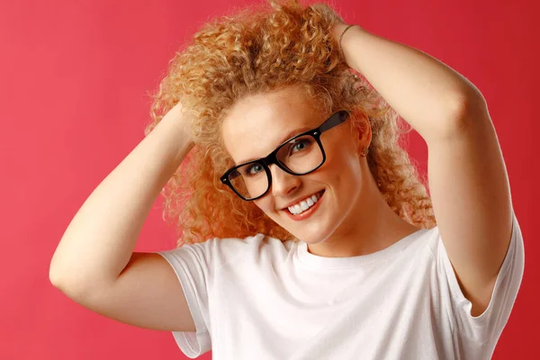 Joyeuse jeune femme bouclée dans des lunettes souriant — Photo