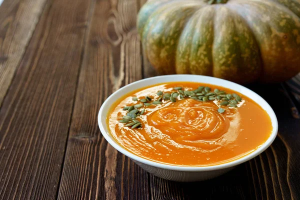 Creamy pumpkin soup on a wooden table — Stock Photo, Image