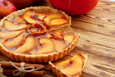 Elmalı turta ve tahta masada kırmızı elmalar.