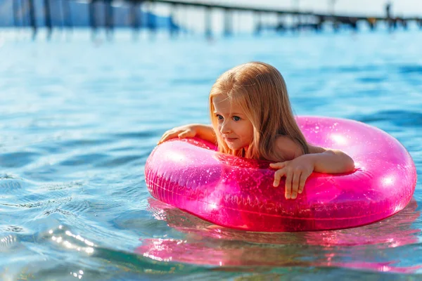 Petite fille avec cercle gonflable rose se baignant dans la mer — Photo