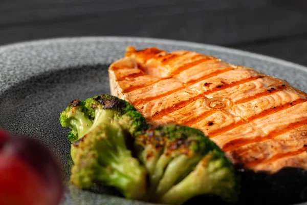 Lachssteak vom Grill mit Brokkoli auf grauem Teller — Stockfoto