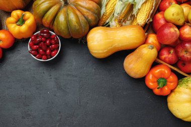 Siyah zemin üzerinde balkabakları ve elmalar olan sebze bileşiminin üst görünümü