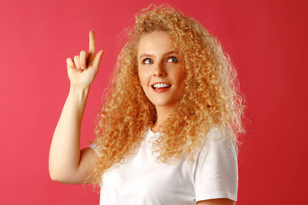 Young attractive blonde woman pointing her finger to copy space