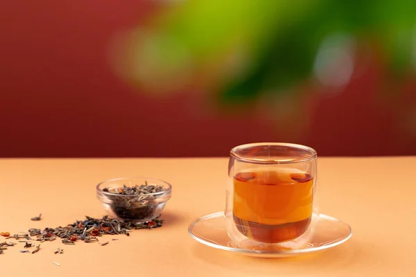 Glasschale mit schwarzem Tee auf beigem Tisch — Stockfoto