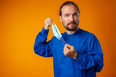 Medikal yüz maskesi takan orta yaşlı beyaz bir adam..