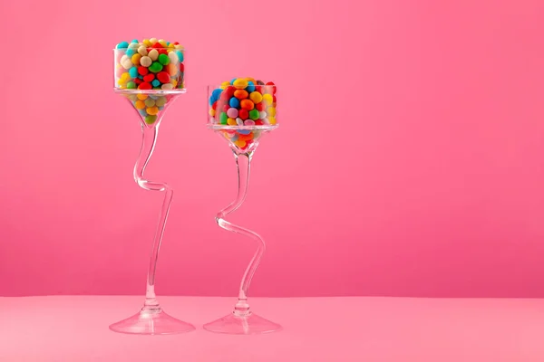 Glasbehälter mit Bonbons vor rosa Hintergrund — Stockfoto