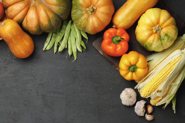 Φθινοπωρινή σύνθεση λαχανικών με κολοκύθα, καλαμπόκι και πιπέρι σε μαύρο φόντο — Φωτογραφία Αρχείου