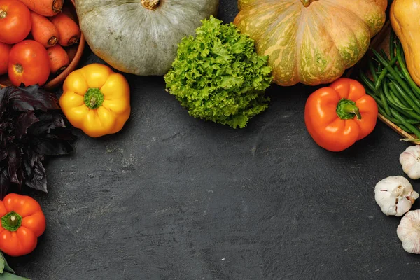 Asortyment warzyw, w tym dyni, pomidorów i papryki na czarnym tle — Zdjęcie stockowe