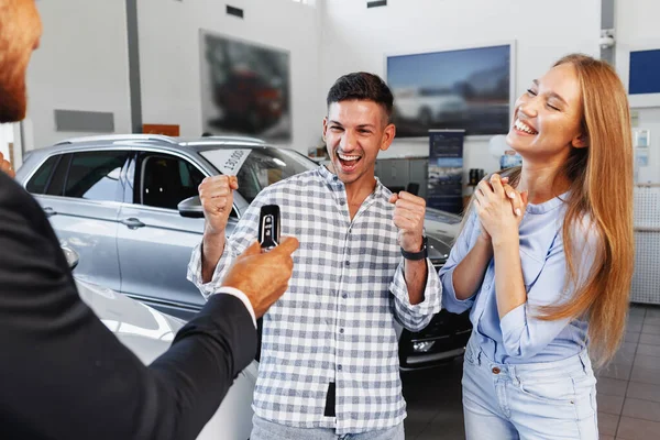 Unbekümmertes junges Paar beim Neuwagenkauf im Autohaus — Stockfoto