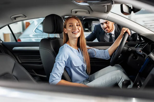 Mujer feliz propietario de coche nuevo sentado en el asiento del conductor — Foto de Stock