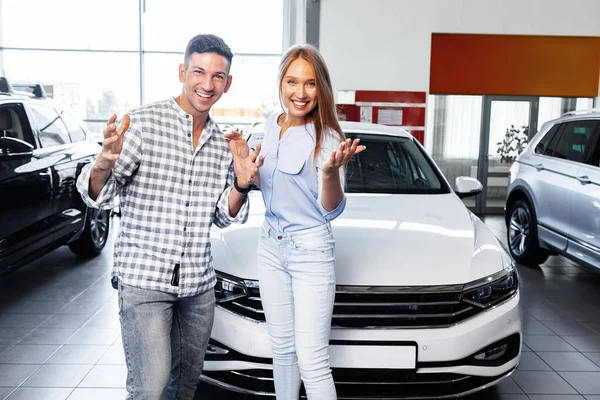 Pečlivý mladý pár v prodejně kupovat nové auto — Stock fotografie
