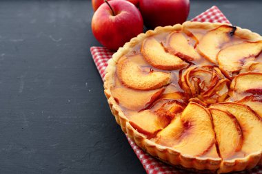 Elmalı turta ve tahta masada kırmızı elmalar.