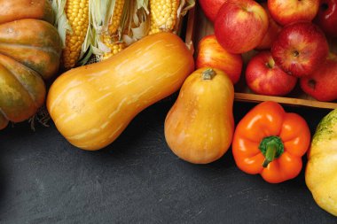 Siyah zemin üzerinde balkabakları ve elmalar olan sebze bileşiminin üst görünümü