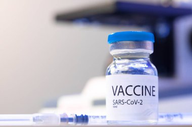 Laboratuvardaki masada Sars-cov-2 aşısı şişesi var.