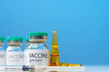 Sars-cov-2 aşı şişesi ve şırınga beyaz masa üzerinde